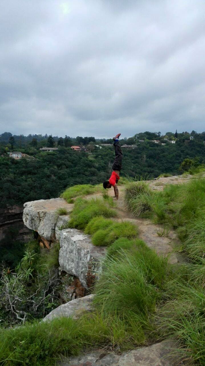 Picture of Kyle doing a handstand at the edge od a cliff